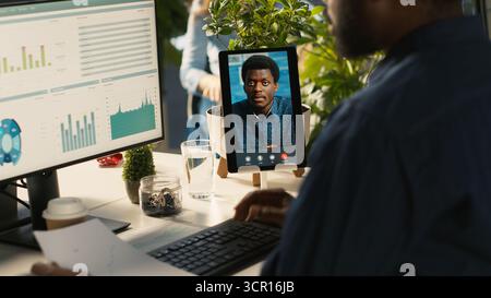Worker in office talking with manager supervising tasks progression during online videocall. Employee discussing with supervisor overseeing work done during remote teleconference meeting, , camera A Stock Photo