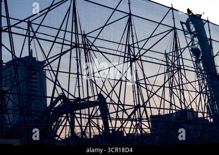 Construction site with protective netting and scaffolding at sunrise or sunset Stock Photo