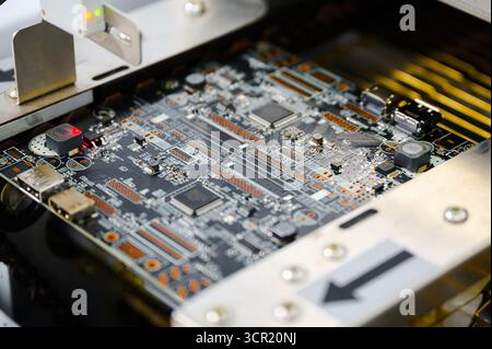Circuit board undergoing quality control inspection in a modern manufacturing facility Stock Photo
