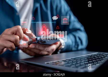 Cybersecurity warning concept with businessman using smartphone and red alert icons, online fraud Stock Photo