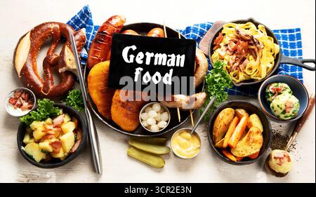 Various austrian dishes- schnitzel, sausages, potatoes, Knodel, salad and sauces on a light background. Top view. Stock Photo