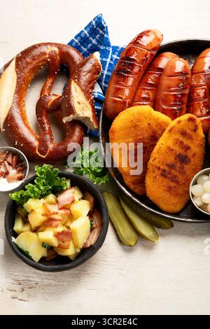 Various austrian dishes- schnitzel, sausages, potatoes, Knodel, salad and sauces on a light background. Top view. Stock Photo