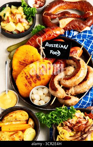 Various austrian dishes- schnitzel, sausages, potatoes, Knodel, salad and sauces on a light background. Top view. Stock Photo