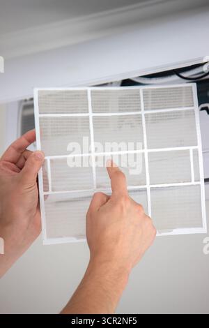 Air Conditioner Maintenance: Removing a Dirty Air Filter. Stock Photo