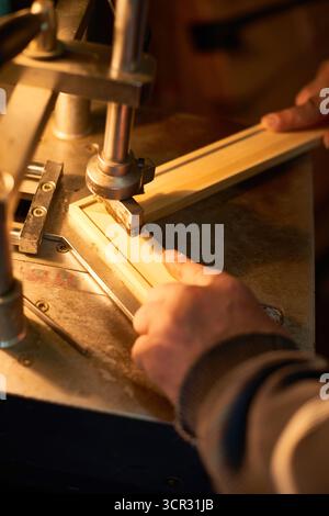 Man Assembling Wooden Frame Using Industrial Machine Stock Photo