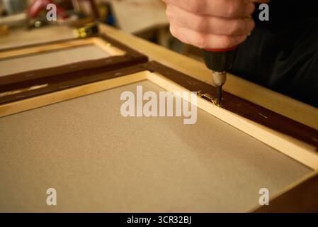 Man Assembling Wooden Frame Using Electric Screwdriver Stock Photo