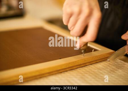 Man Assembling Wooden Frame Using Hand Tools Indoors Stock Photo
