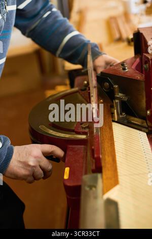 Man Operating Industrial Wood Cutting Machine Indoors Stock Photo