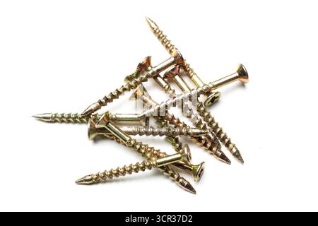 Collection of metal screws on a white surface arranged in a casual fashion Stock Photo