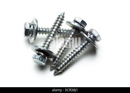 Metal screws stacked on a white background ready for construction projects Stock Photo