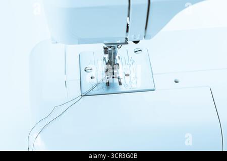Sewing machine in use during daylight hours showcasing needle and thread activity Stock Photo