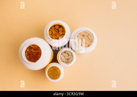 Mixed supplement containers top view on warm neutral background with copy space Stock Photo
