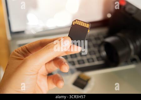 Photographer's hand holding memory card for preparing his camera before photography. Close-up, selective focus. Stock Photo