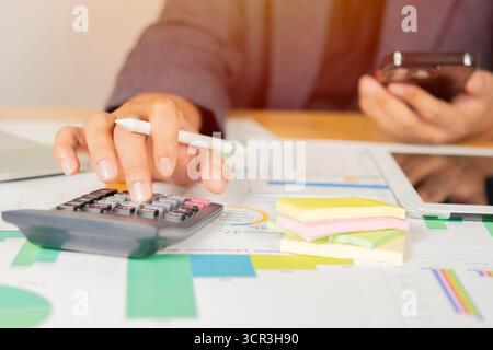 Business man or accountant working on calculator to calculate business data in modern office. Financial and tax systems concept Stock Photo