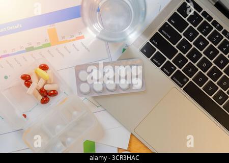 Medicine caps pills capsule pack on laptop computer keyboard, Office syndrome medical treatment from hard working with computer concept. Stock Photo
