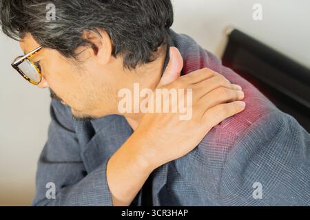 Tired millennial office worker stretch houlder pain because suffer from sitting long in incorrect posture. Close-up, selective focus. Stock Photo