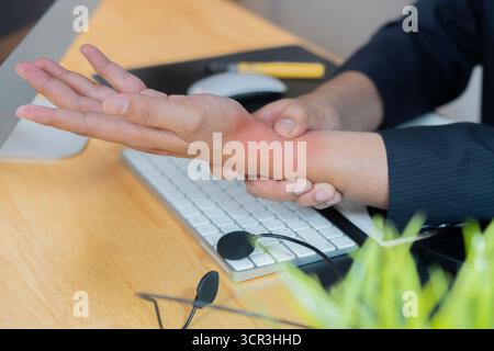 Business man, hands and wrist injury with computer for pain, discomfort or carpal tunnel syndrome at office. Side view close-up. Stock Photo