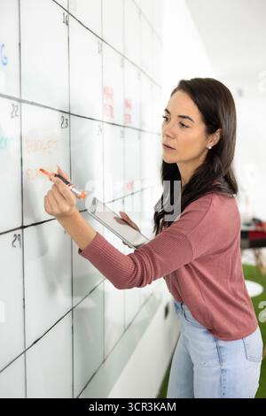 Focused woman prepare schedule for staff members Stock Photo