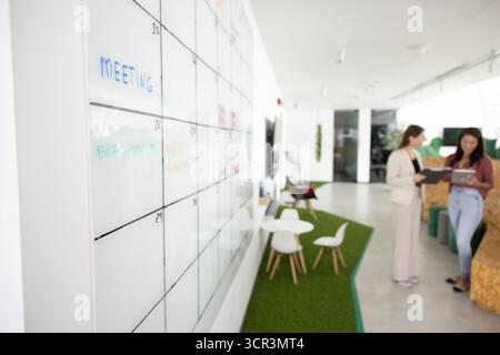 Two women professionals engaged in discussion in modern coworking Stock Photo