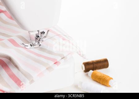 Sewing machine in action creating a striped fabric project at home Stock Photo