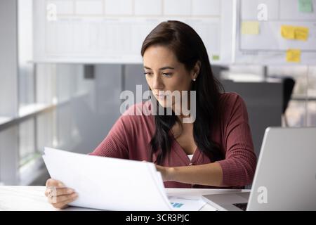 Focused professional woman working with documents in workplace Stock Photo