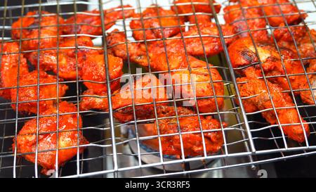 Authentic tandoori chicken, marinated in yogurt and spices, grilled in a tandoor for a smoky flavor. A popular Indian cuisine dish, enjoyed worldwide Stock Photo