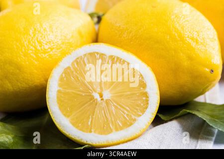 Fresh Lemons, Whole and Sliced on a Rustic Background Stock Photo