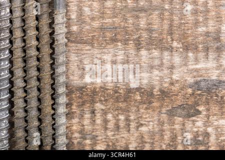 Close-up view of screws arranged on rustic wooden surface with visible grain Stock Photo