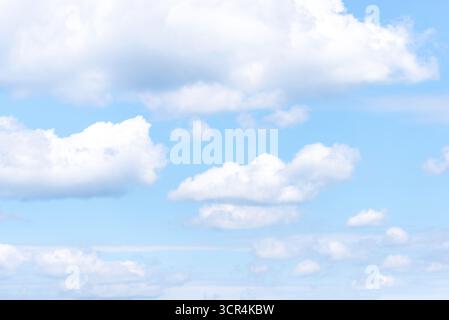 Scenic sky with fluffy white clouds and soft light on clear summer day. Stock Photo