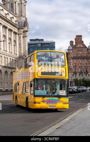 A yellow Liverpool City Tour bus outside the Port of Liverpool building in Albert Dock, Liverpool, UK Stock Photo