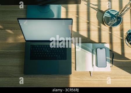 Workspace Laptop Notebook Smartphone Topview screen mockup Organized modern office desk with open laptop, dotted notebook, pen, and smartphone arrange Stock Photo