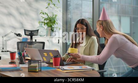 Birthday celebration corporate office amazed happy Indian businesswoman Arabian woman laptop busy diversity friendly business coworkers surprising Stock Photo