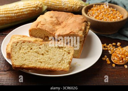 Freshly baked cornbread, cobs and seeds on wooden table, closeup Stock Photo