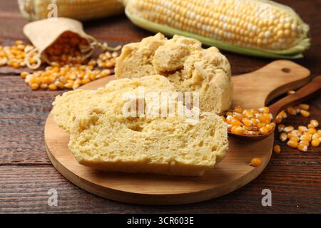 Freshly baked cornbread, cobs and seeds on wooden table, closeup Stock Photo