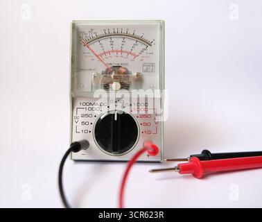 Isolated analog multimeter and its probes. Vintage testing tools. Voltmeter, ohmmeter and ammeter all in one body. Stock Photo
