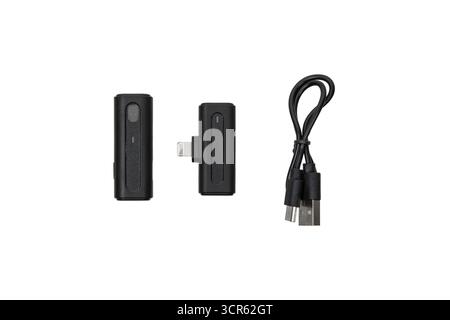Wireless microphone transmitter, receiver, and charging cable isolated on white background. Stock Photo