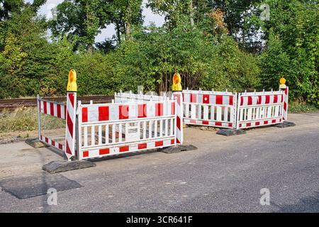 Road construction barriers with safety lights and red white warning signs on street Stock Photo