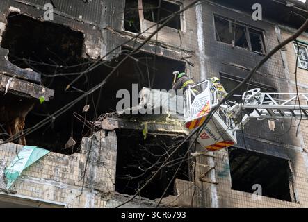 Rescue workers seen actively clearing debris from a heavily burned and structurally damaged Kyiv residential building following a Russian air attack, alongside sections with shattered windows. Following a massive shelling attack on Kyiv by Russia on Sunday night, using UAVs and missiles, four fatalities have been confirmed, including a 12-year-old child, along with 13 injured persons. Rescue operations at the strike sites, which affected 32 locations-including residential buildings, civilian infrastructure, and the Representation of the European Union in Ukraine-have now concluded. The attack Stock Photo