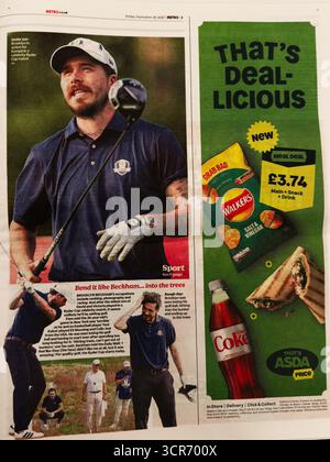 London, UK - September 26, 2025: Male golfer in a polo shirt and cap practicing on a sunny golf course with adjacent advertisement Stock Photo