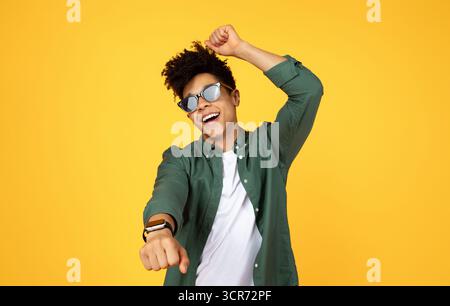 Carefree young black guy wearing sunglasses dancing Stock Photo
