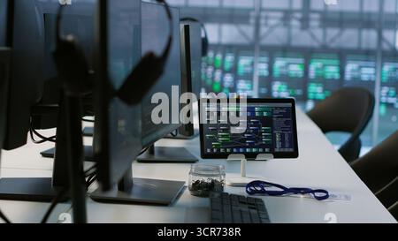 Close up of headphones left by worker on server room PCs used by employees working to ensure minimal downtime. Equipment in data center workplace used for monitoring performance Stock Photo