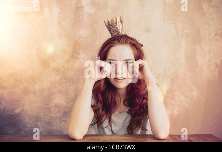 red-haired young woman with a crown in her hair is said Stock Photo