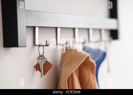 Rack with keys from house on light wall, closeup Stock Photo