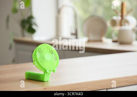 Green mini fan on table in kitchen, closeup Stock Photo