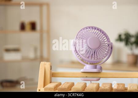 Lilac mini fan on shelf in kitchen, closeup Stock Photo