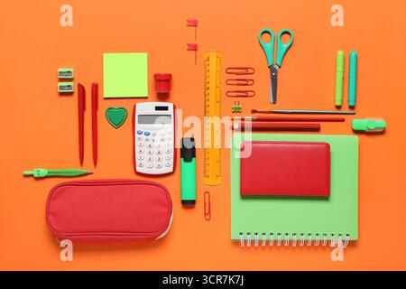 Pencil case with different school stationery supplies on orange background Stock Photo