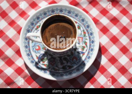 Turkish coffee on a decorative cup with checkered cloth Stock Photo