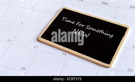 Time For Something New: Chalkboard Sign on a Calendar Emphasizing Change, Start, or Opportunity. Stock Photo