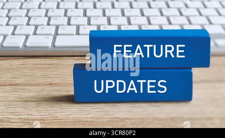FEATURE UPDATES Text on Blue Blocks with Computer Keyboard Background for Software or Product Development Stock Photo