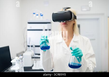 Professional scientist using VR headset in chemistry lab for interactive molecular modeling, representing future of research and immersive technology. Stock Photo